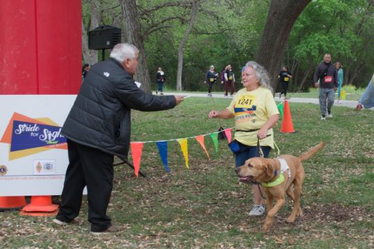 Photo of a 5K participant and her dog crossing the finish line